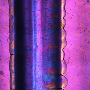 Eine ultraschallgesiegelte Naht in der Draufsicht unter dem Mikroskop mit polarisiertem Licht.