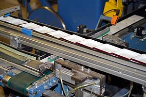 Die neue Konfektionieranlage für Kappenschachteln fügt mit bis zu 120 Takten pro Minute die Einzelteile zu hochwertigen Verpackungen zusammen.