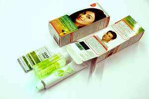 Die Kit-Packungen mit Tube, Flasche, Handschuh und Beipacxkzettel werden von der Kartoniermaschine automatisch verpackt. 
