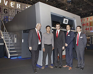 Zhang Bao Lin, Eigentümer und Präsident der Changchun Boshiheng Printing Company (2. von links), sowie Stephan Plenz, Mitglied des Vorstands bei Heidelberg (3. von links), zusammen mit Mitgliedern des Vertriebsteams von Heidelberg vor dem auf der drupa gezeigten Ausleger einer Speedmaster XL 162.