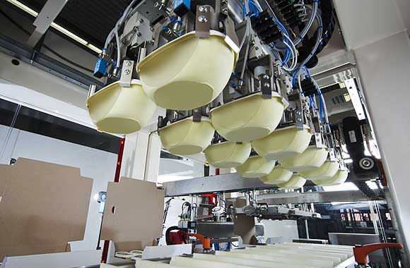 Das Dutzend fest im Griff: Butterbecher in der zarten Führung der Roboter in der TLM-Maschine von Schubert.