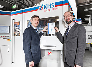 Rechts im Bild Dr. Michael Bunk, leitender Auditor TÜV SÜD. Er übergibt das Zertifikat „Energieeffiziente Anlagentechnik“ für die Streckblasmaschinen der Baureihe InnoPET Blomax Serie IV an Dr. Thomas van Hamme, Leiter Konstruktion und Entwicklung KHS Corpoplast.