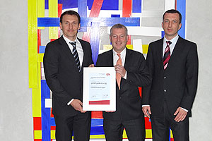 Jürgen Scherer, Zentraleinkauf Verpackungen (links), und Robert Ruisinger, Müller Einkauf & Service AG (rechts), bei der Überreichung des Awards an Ralf Jung, Geschäftsführer Gizeh Verpackungen (Mitte).