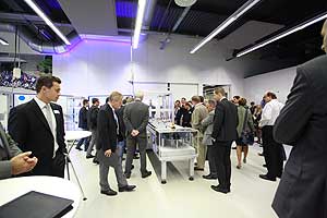 Die neue Kartoniermaschine vom Typ VI 5 umringt von interessierten Besuchern der Hausmesse. 