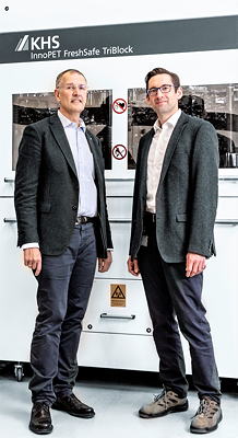 Bernd-Thomas Kempa (l.) und Dr. Joachim Konrad (r.) vor einem InnoPET FreshSafe TriBlock mit Streckblasmaschine und Kombination von Füller und Verschließer. Dieser erreicht eine Leistung von bis zu 48.000 Flaschen pro Stunde.