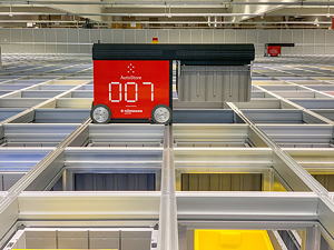 Das neue Lager setzt auf ein modulares System, bei dem stapelbare Kistenbehälter von Robotern beladen, eingelagert und entladen werden.