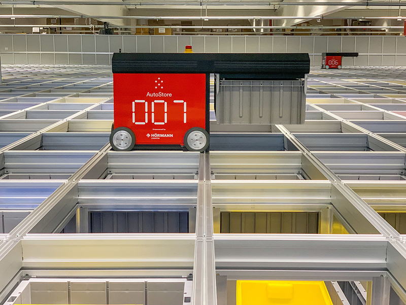 Das neue Lager setzt auf ein modulares System, bei dem stapelbare Kistenbehälter von Robotern beladen, eingelagert und entladen werden.