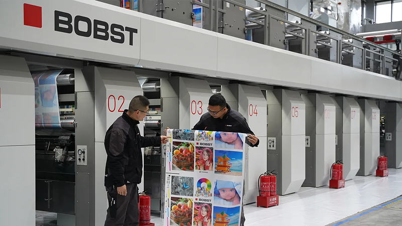 Messrs Shuhui Sun (right) and Bo Zhang (left), process engineers at Bobst Changzhou, examining the technical print sample printed on the new BOBST RS 3.0 HS gravure press using Siegwerk water-based inks in Bobst (Changzhou) Competence Center.