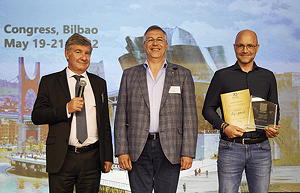 Von links nach rechts: EUROSAC-Präsident Olivier Tassel und Jurypräsident Herbert Rode gratulieren dem Gewinner des goldenen EUROSAC Grand Prix Award dy-pack, vertreten durch Peter Perrone.